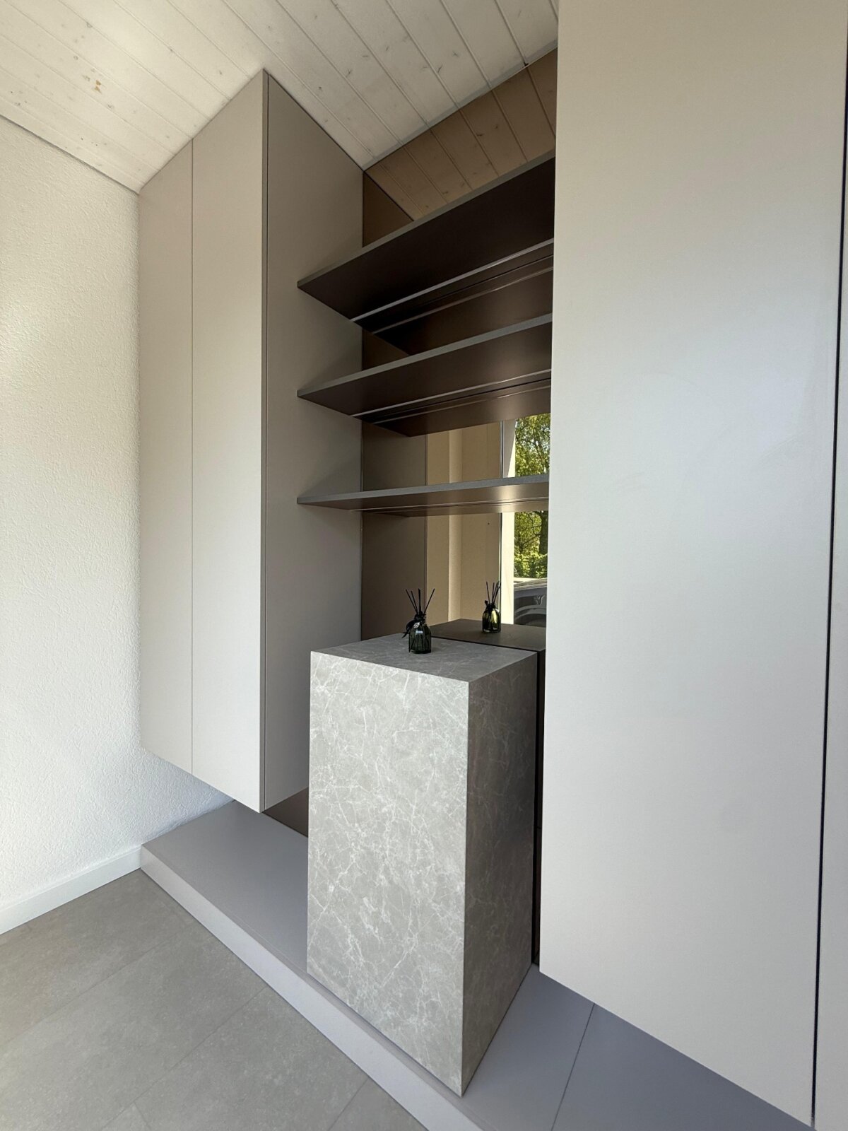 Der Salon nach dem Umbau: Nische mit offenem Regal und Marmorblock