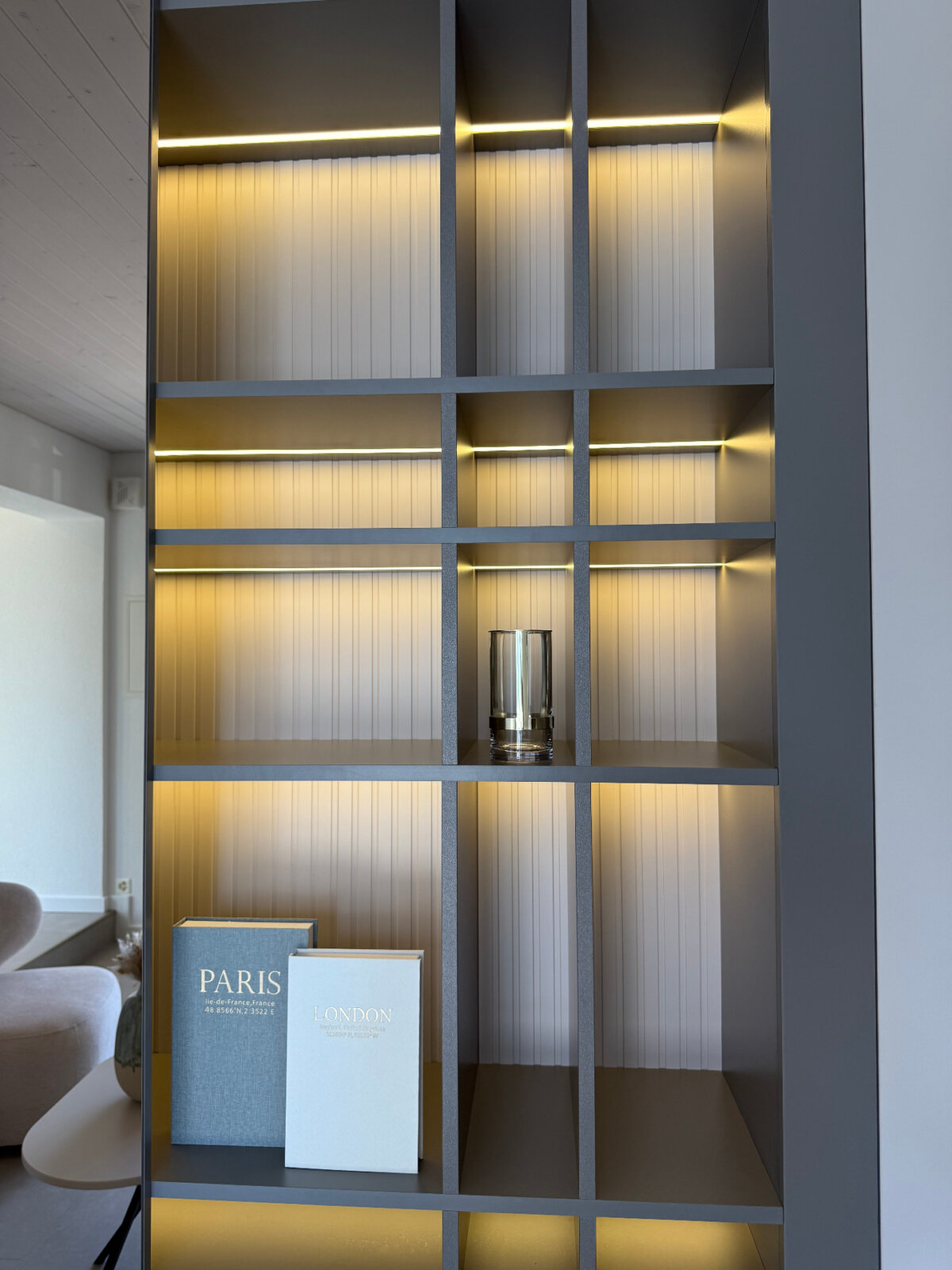 Beleuchtete Regalwand mit Büchern und Dekoration