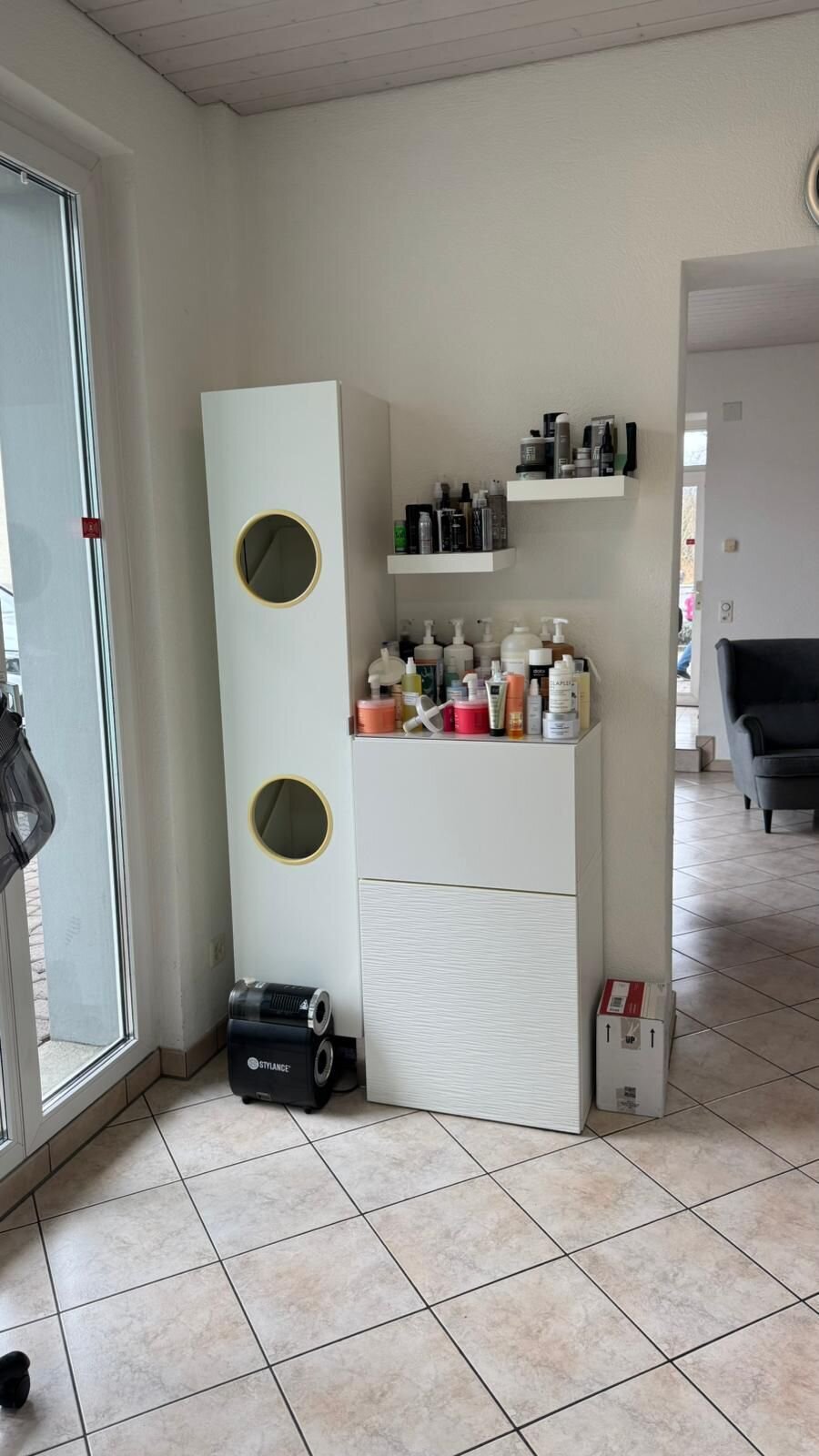Regal mit Pflegeprodukten an der Fensterfront vor dem Umbau